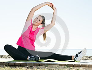 Woman exercising yoga poses on beach