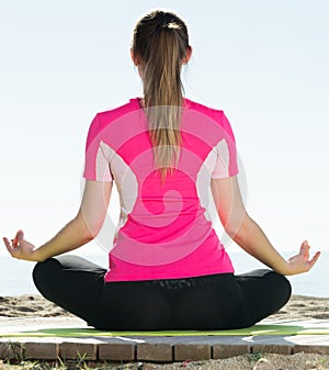 Woman exercising yoga poses on beach