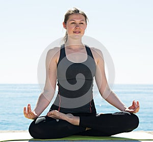 Woman exercising yoga poses on beach