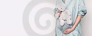 Woman expecting baby. Pregnant girl touching belly and teddy bear toy resting, awaiting the child birth. Natural