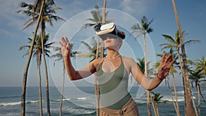 Woman experiences VR game on tropical beach, gesturing, immersed in virtual gameplay. Interactive tech entertainment by