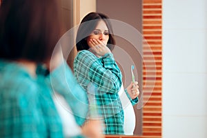 Pregnant Woman with Morning Sickness Looking in the Mirror photo