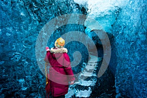 Woman exploring blue ice cave in Iceland