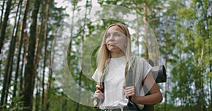 Woman exploring glade with ferns in the woods. hiking woman walk in rainforest jungle. Girl hiker walking with backpack