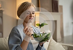 Woman Expresses Discontent While Eating Tasteless Salad at Home