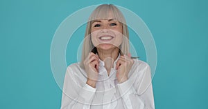 Woman Expressing Amazement and Exclaiming Wow to the Camera on Blue Background