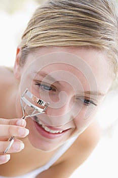 Woman with eyelash curler