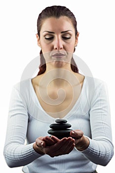 Woman with eyes closed while holding pebbles