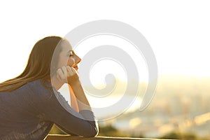 Woman with eyes closed relaxing at sunset