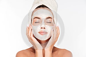 Woman with eyes closed and white facial mask on face