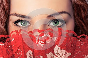 Woman eyes and face hide with red fan