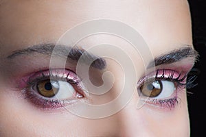 Woman eyes with perfect pink wet eyeshadow closeup studio