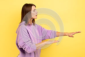 Woman with eyesight problems trying to move with closed eyes touching space around with hands.