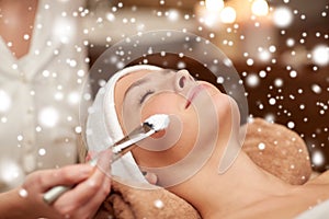 Woman face and beautician applying mask in spa