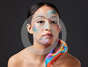 Woman, face and beauty portrait with color paint art on hand in studio. Creative skin and makeup on female aesthetic