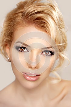 Woman face close up. A pretty young blond trendy. Girl with a be