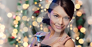 Woman face with cocktail over christmas lights