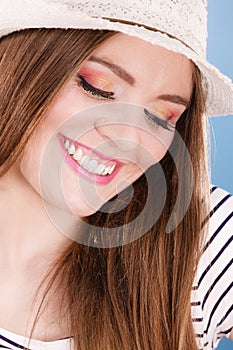 Woman face colorful eyes makeup, summer straw hat smiling