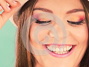 Woman face colorful eyes makeup, summer straw hat smiling