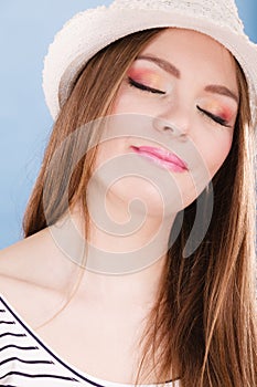 Woman face colorful eyes makeup, summer straw hat smiling