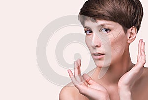 Woman face covered with cracked earth texture- symbol of dry skin