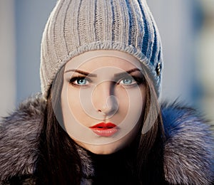 Woman face fur coat and gray hat, blue con