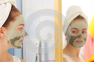 Woman face with green clay mud mask