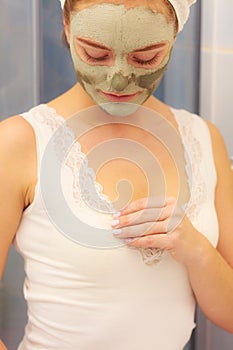 Woman face with green clay mud mask