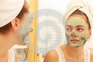 Woman face with green clay mud mask