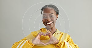 Woman, face and heart hands in studio, love and hope for wellness and satisfaction. Black female person, portrait and