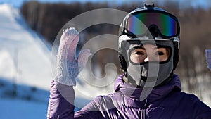 Woman face in a helmet and a mask from cold, frost and wind puts on sunglasses preparing for skiing.Mountaineering ski