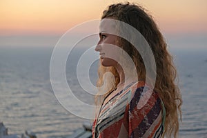 Woman face looking at sunset and sea view from terrace of luxury holiday villa