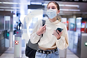 Woman in face mask enter in subway through turnstile