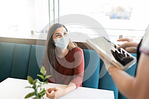 Woman In Face Mask Giving Order At Cafe