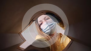 woman face in mask opens a packet bag of food meal. contactless delivery fast food quarantine coronavirus concept. adult