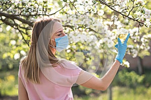 Woman with face mask on quarantine. Stay at home. Family concept. young woman blowing dandelion. glass of champagne on the beach.G photo