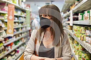 Woman in face mask shopping in supermarket.