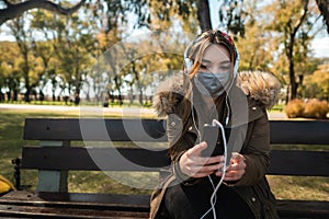 Woman with face mask sitting at park