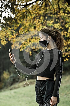 Woman with face mask taking video call. Giving lectures while working out during covid-19 photo