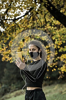 Woman with face mask taking video call. Giving lectures while working out during covid-19 photo