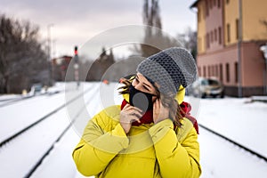 Woman with face mask waiting for train at railroad station