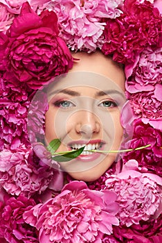 Woman face in peony flowers