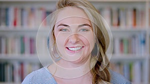 Woman, face portrait and smile in library for happy learning, education and university student study in bookshop. Books