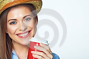 Smiling girl posing on white background with red coffee cup.