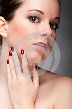 Woman face with red fingernail