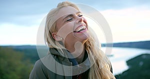 Woman, face and smile on hike in outdoors, relaxed and view of nature on adventure in Norway. Happy female person