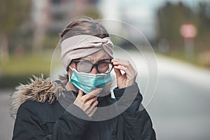 Woman with facemask and tarnished glasses, corona concept