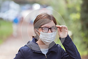 Woman with facemask and tarnished glasses. Portrait corona concept