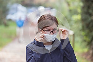 Woman with facemask and tarnished glasses. Portrait corona concept