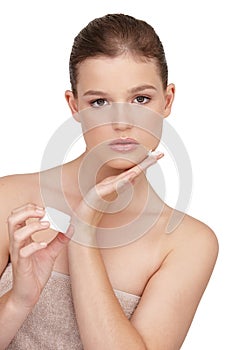 Woman, facial cream and towel in studio portrait for cosmetics, skincare or beauty exfoliation. Female person, cleaning